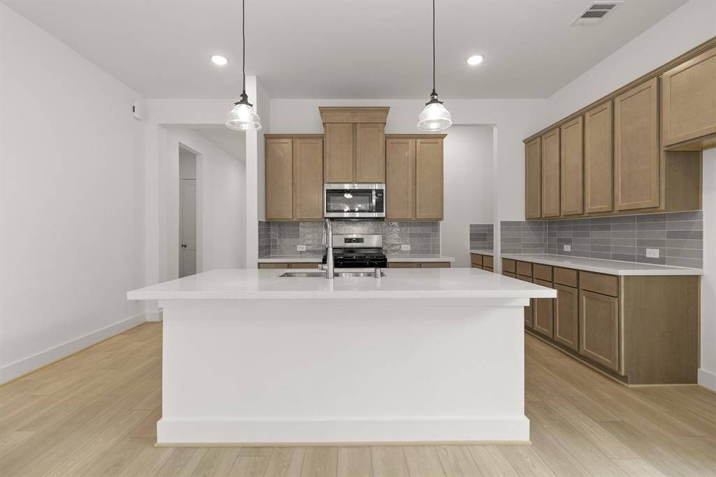 The spacious open-concept kitchen is a perfect blend of warmth and modern style, featuring