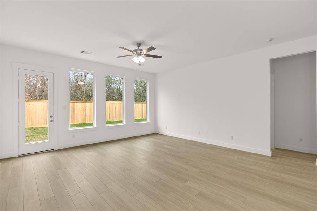 The living room is bathed in natural light from the oversized windows, complementing the s