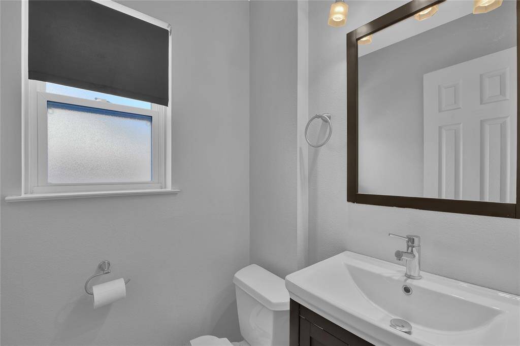 Sleek Powder Room with Combination Toilet/Bidet, Conveniently Located Near Kitchen and Laundry Area