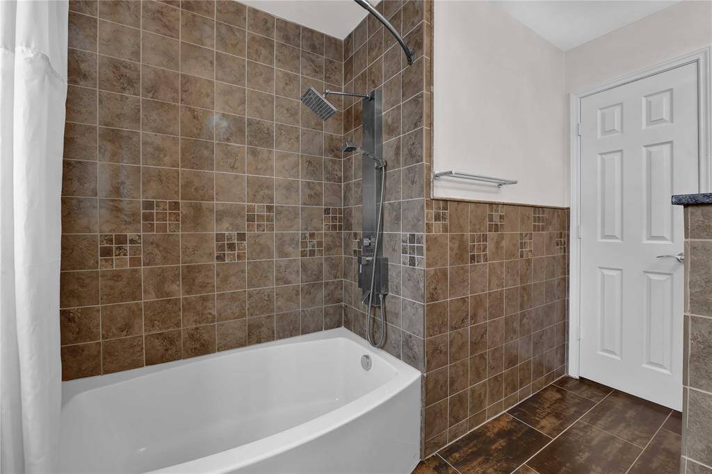 Inviting guest bath with a luxurious soaking tub and shower combo, featuring high-quality fixtures for a spa-like experience.