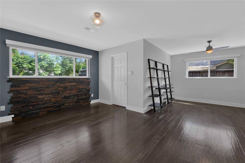 Elegant Primary Suite with Chic Wood Accent Wall and Cozy Sitting Area