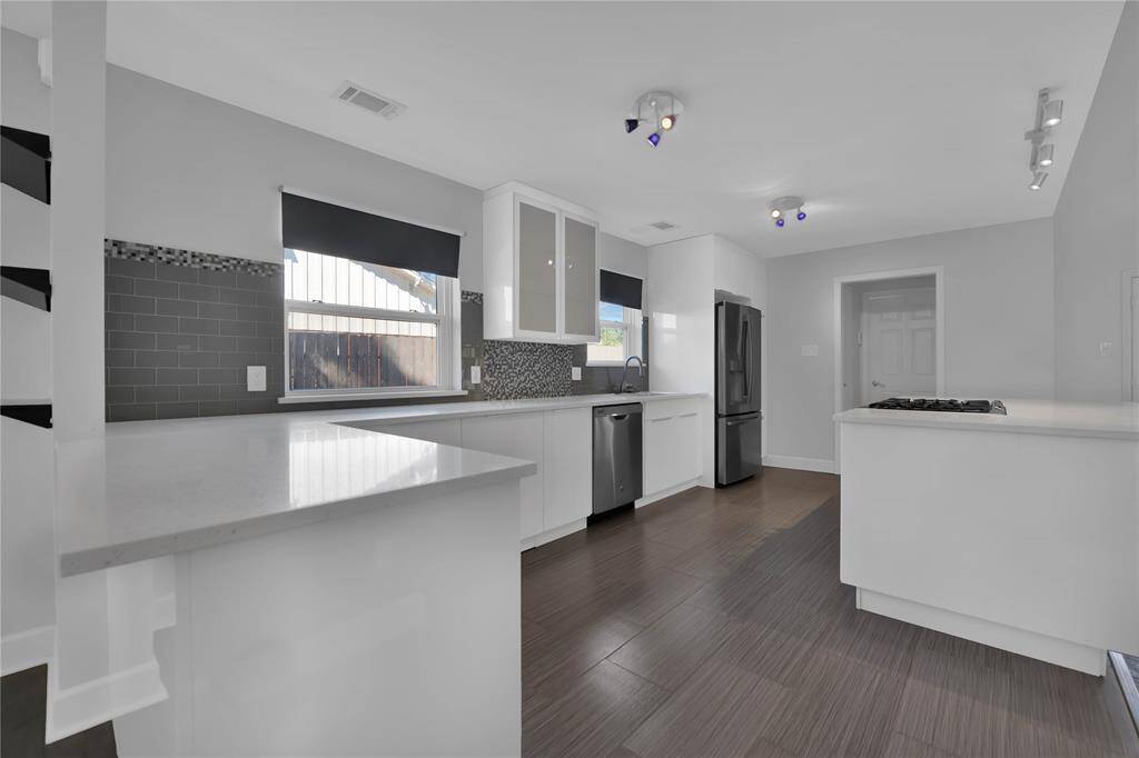 Spacious Chef's Kitchen with Ample Quartz Countertops, Modern Cabinetry, and Central Cooktop Island.