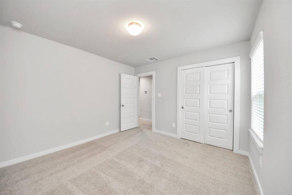 Generously sized secondary bedrooms featuring spacious closets, soft and inviting carpeting underfoot, large windows allowing plenty of natural light, and the added touch of privacy blinds for your personal retreat.