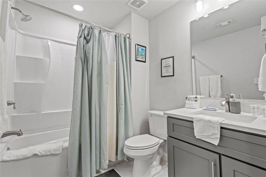 Spacious laundry room with ample shelving and direct backyard access.