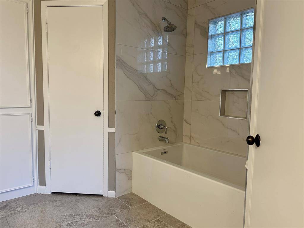 Primary Bathroom features his & hers closets and tiled tub/shower combo