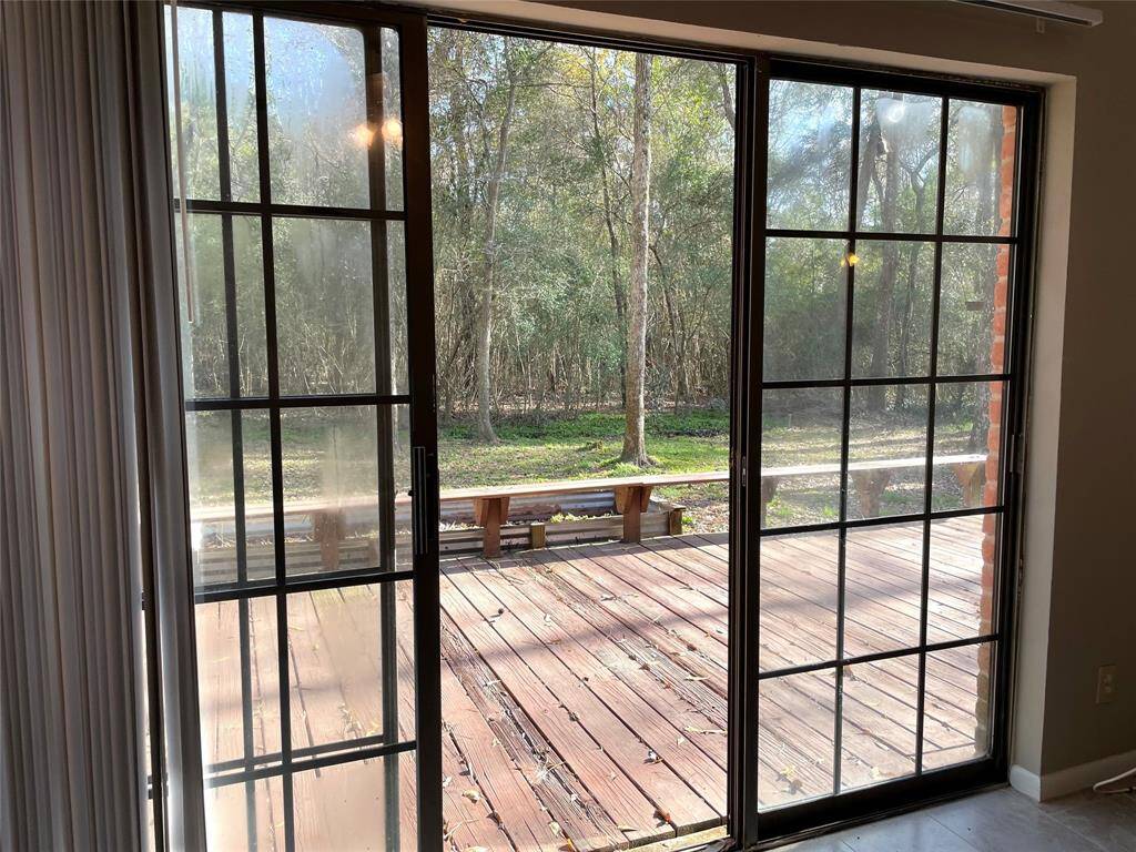 Sliding doors in Primary Bedroom lead to over-sized entertainment deck and beauiful tree views