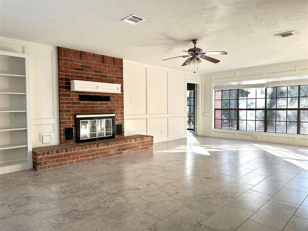 Gorgeous brick fireplace and built-in shelving adds charm