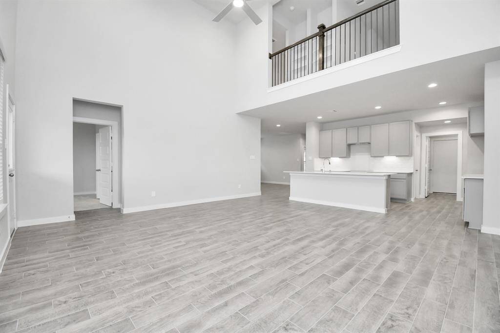 Bring your loved ones and guests together in the inviting living room! Boasting lofty high ceilings, recessed lighting, a stylish ceiling fan, custom paint, stunning flooring, and expansive windows that flood the space with ample natural light all day long.