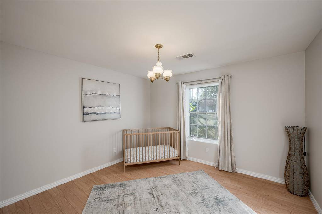 One of the two bedrooms down that can be a secondary primary with hard surface flooring and large closet that opens to the full bathroom.