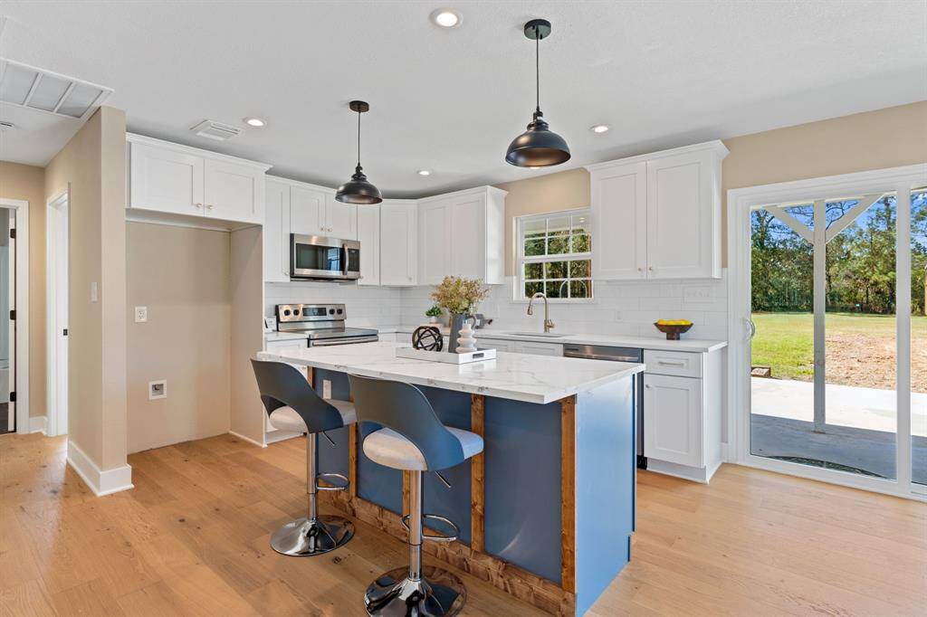 Kitchen features new quartz countertops with all new wood cabinetry with softclose doors and drawers and kitchen island.