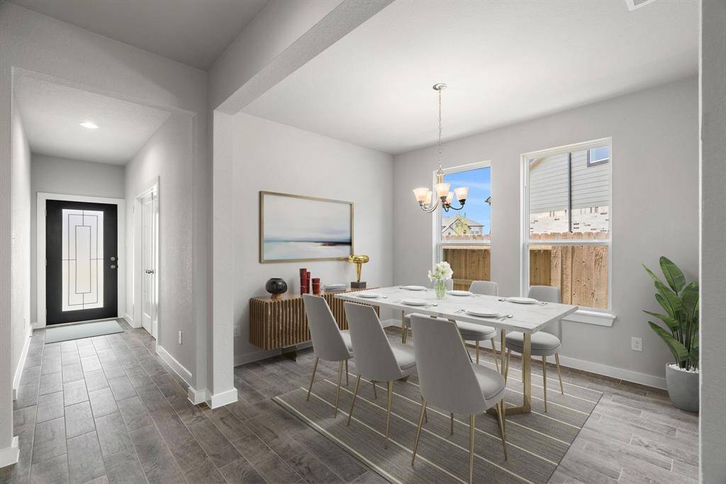 Create cherished moments with loved ones in this expansive dining room, boasting elegant flooring, custom paint, and seamless flow to the family room and kitchen. Sample photo of completed home with similar floor plan. Virtually staged.