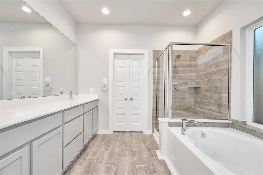 The primary en-suite has a soaking tub to give you that spa experience. The large privacy window allow lots of nature light in the space. Sample photo of completed home with similar floor plan. As-built interior colors and selections may vary.