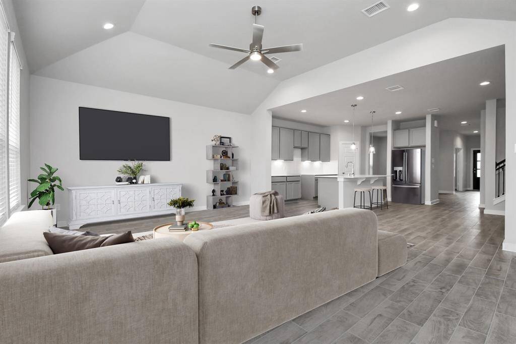 Bring the family and guests together in the welcoming family room! Enjoy the expansive space adorned with high ceilings, recessed lighting, a stylish ceiling fan, custom paint, exquisite flooring, and generously sized windows that fill the room with an abundance of natural light, creating a warm and inviting atmosphere for everyone to enjoy. Virtually staged.