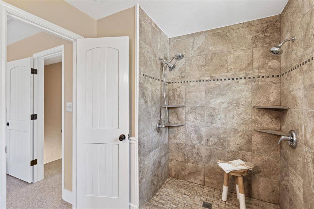 The primary bathroom also has a walk-in shower with tile surround and dual shower heads.