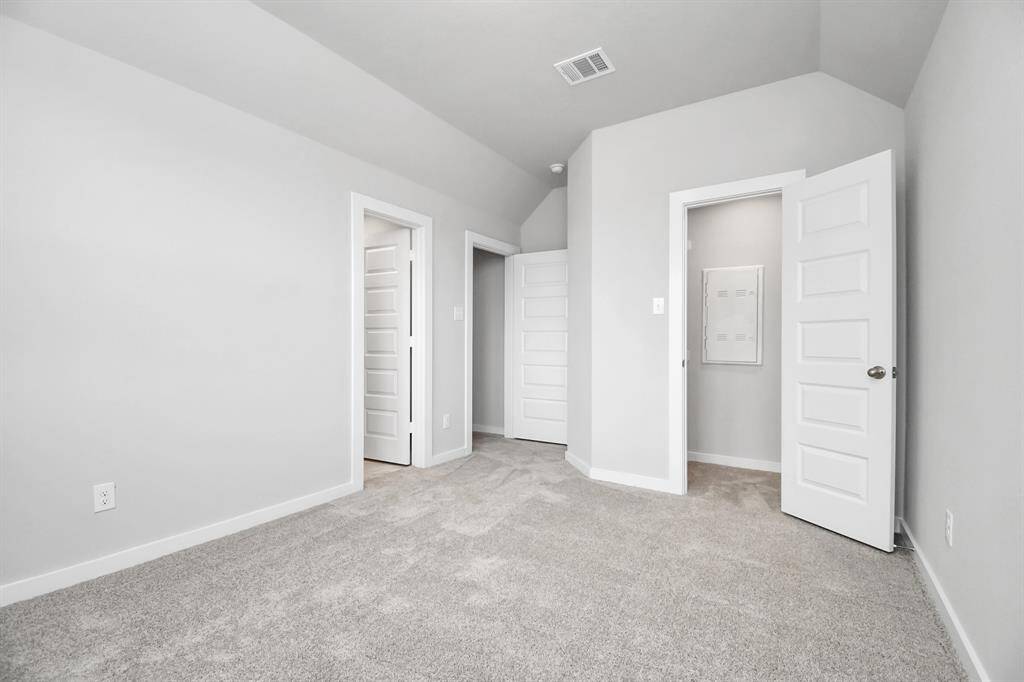 Secondary bedroom features plush carpeting, large windows that let in plenty of natural light, bright paint, and spacious closets.