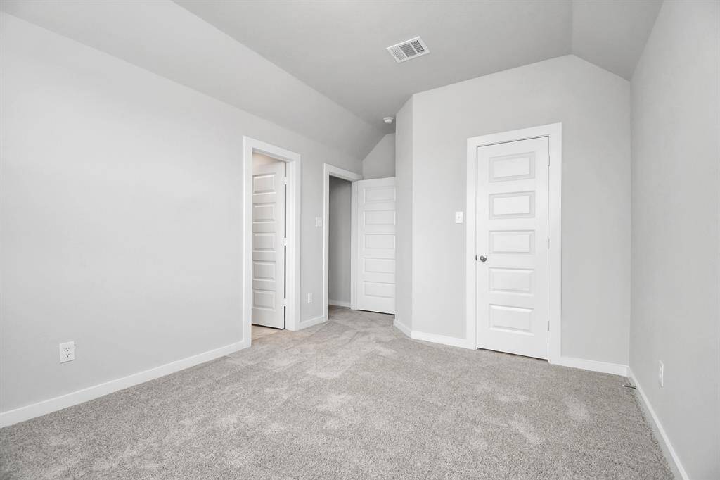 Secondary bedroom features plush carpeting, large windows that let in plenty of natural light, bright paint, and spacious closets.
