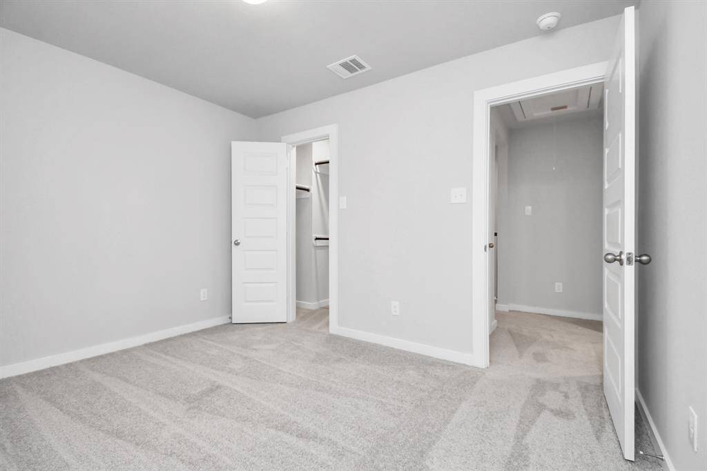Secondary bedroom features plush carpeting, large windows that let in plenty of natural light, bright paint, and spacious closets.