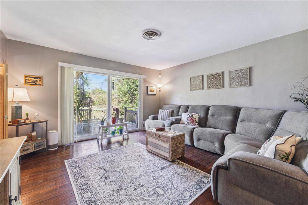 Spacious living room with wood flooring and sliding glass door leading to the backyard