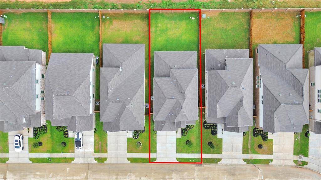 An aerial view of a spacious subdivision lot, highlighting a well-maintained yard and a fully fenced perimeter, offering both privacy and expansive outdoor space.
