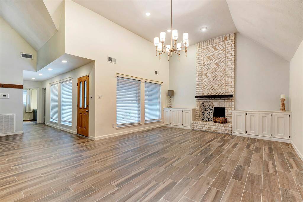 This family room has tile floors and a vaulted ceiling for a spacious feel. The drop chandelier is a beautiful affect. Imagine your beautiful furniture to give it some cozy appeal!