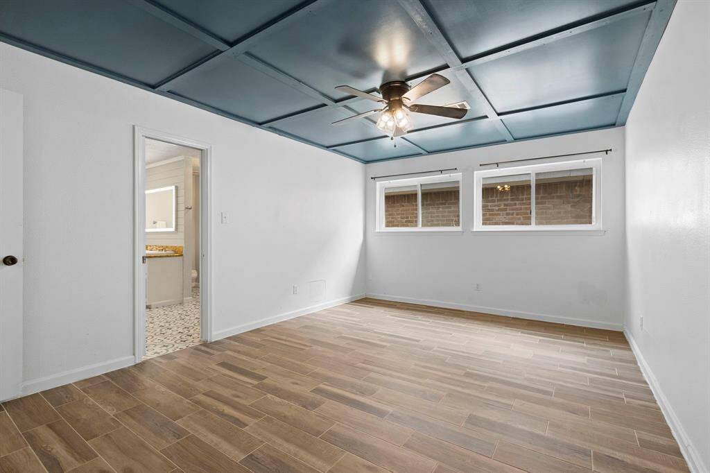 There are 2 primary bedrooms in the home. This is the downstairs primary with detailed ceiling and tile flooring.