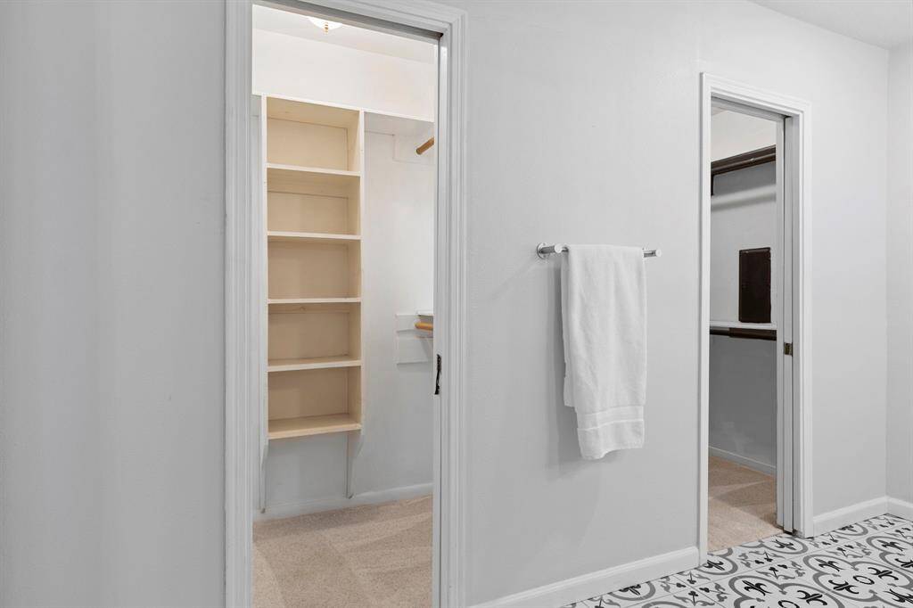 This bathroom has his/her closets that are both generously sized