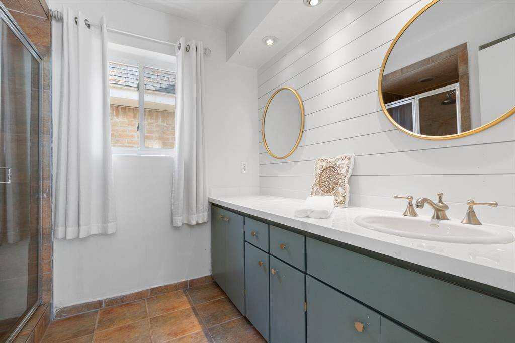 There's a third bathroom downstairs that's adjacent to third bedroom. This bathroom has shiplap accent and updated fixtures. There's a walk in shower in here as well