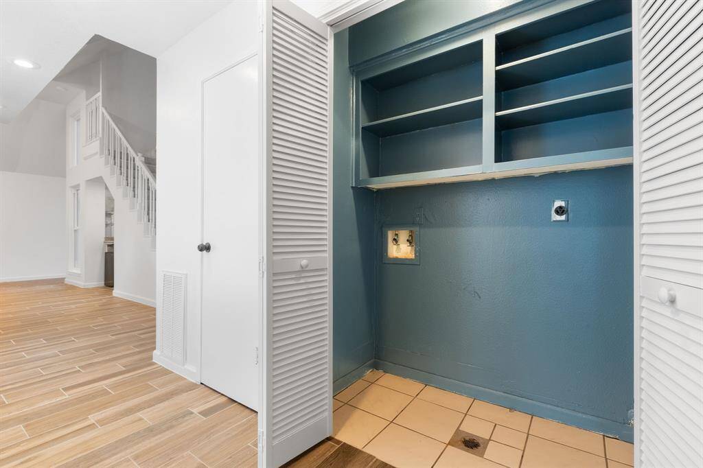 The laundry area has shelves for storage