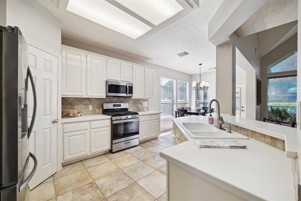 A kitchen perfect for entertaining with wide open spaces to guests! Newly installed SS microwave and GAS range!