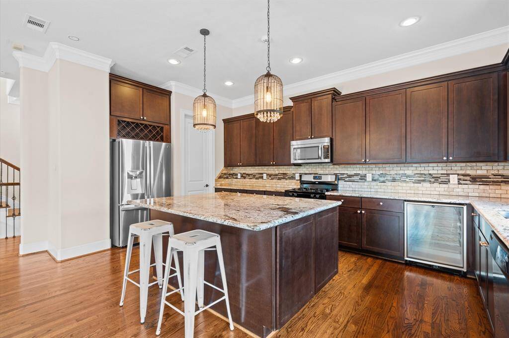 Notice the beverage cooler and the wine storage over the refrigerator flanking the large island!