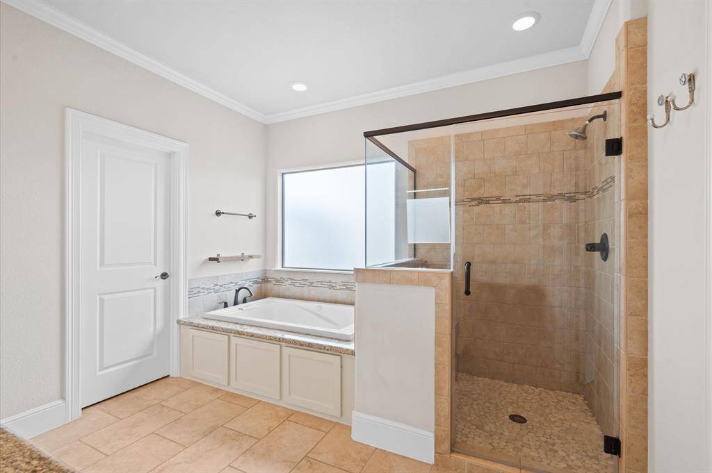 A large tub and spacious glass surround shower in the primary bath!