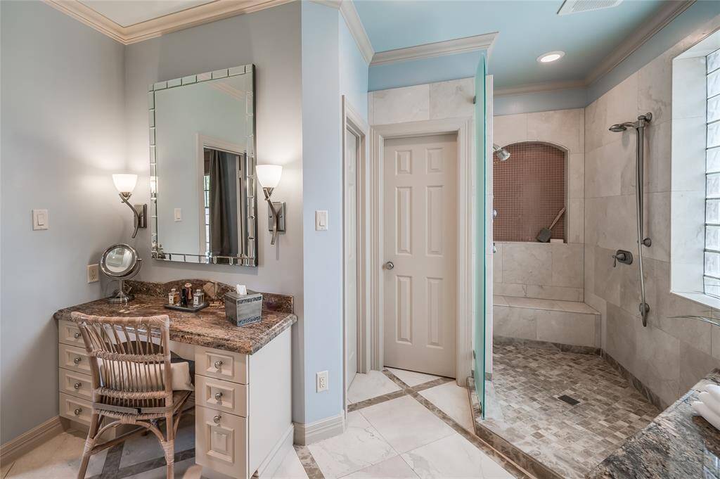 Indulge in a spacious step-in shower and enjoy the convenience of a walk-in closet adjacent to a chic vanity—perfect for starting your day.