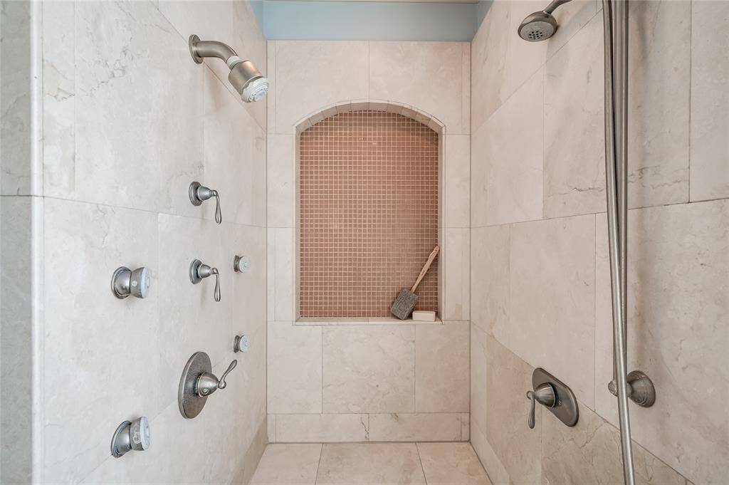 Muted tilework and multiple showerheads in the step-in shower.