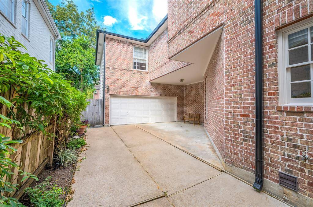 Two-car attached garage equipped with a Tesla EV charger and convenient storage closet.
