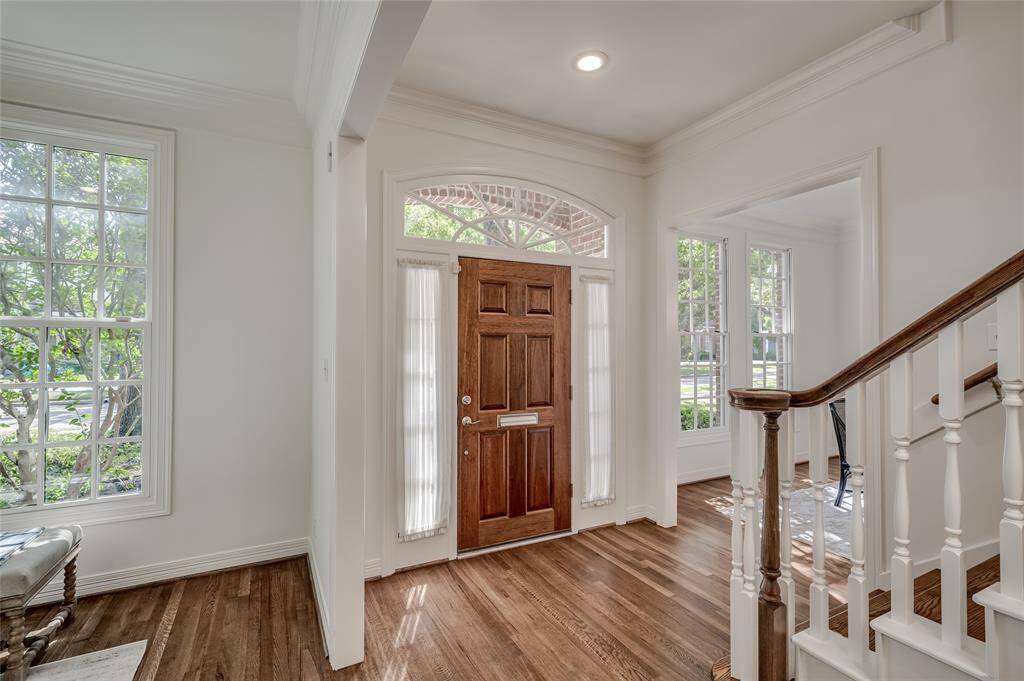 Elegant entryway featuring rich wood floors and expansive windows.