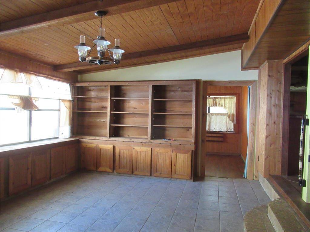 Den room sits just off the living room and has a rustic look with built in bookshelves.