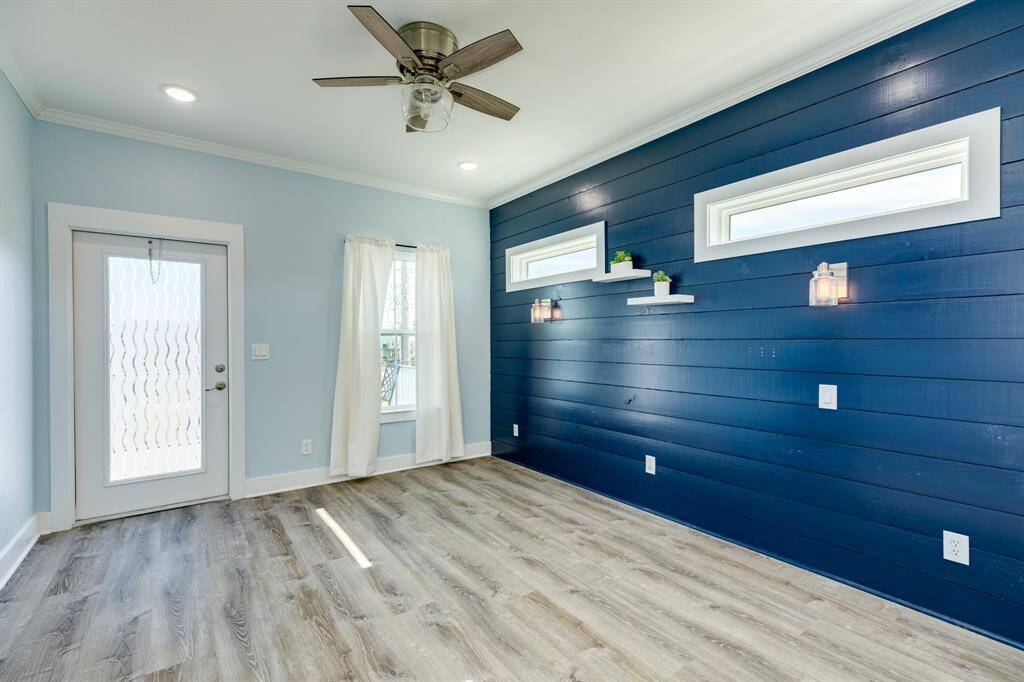 Primary bedroom with accent wall and access to deck