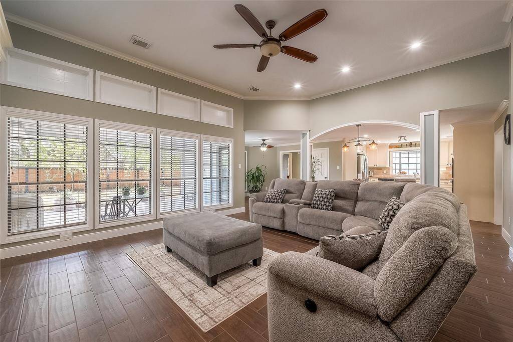 Additional view of the family room featuring large windows offering tons of natural light and opens up to the kitchen and breakfast nook, promoting an open-concept feel.