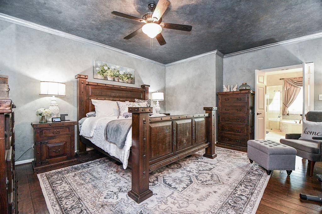 Light pewter wall tones add an exciting dynamic to your huge primary suite, with tons of wall and floor space for all your favorite treasures. The ensuite bath is beyond open double doors, right. Note natural bamboo wood floor, too.