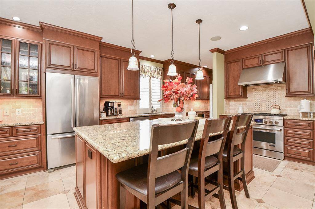 Bright amber toned cabinetry lines your incredible kitchen, top and bottom, with granite counters surrounding your tasks, including easy snacking at this lush center island.
