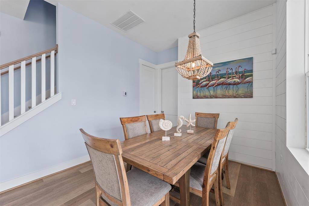 This cozy dining area features arustic wood table, chicchandelier, and shiplap accentwall, creating a warm andinviting space perfect for casualfamily meals or intimategatherings with friends.