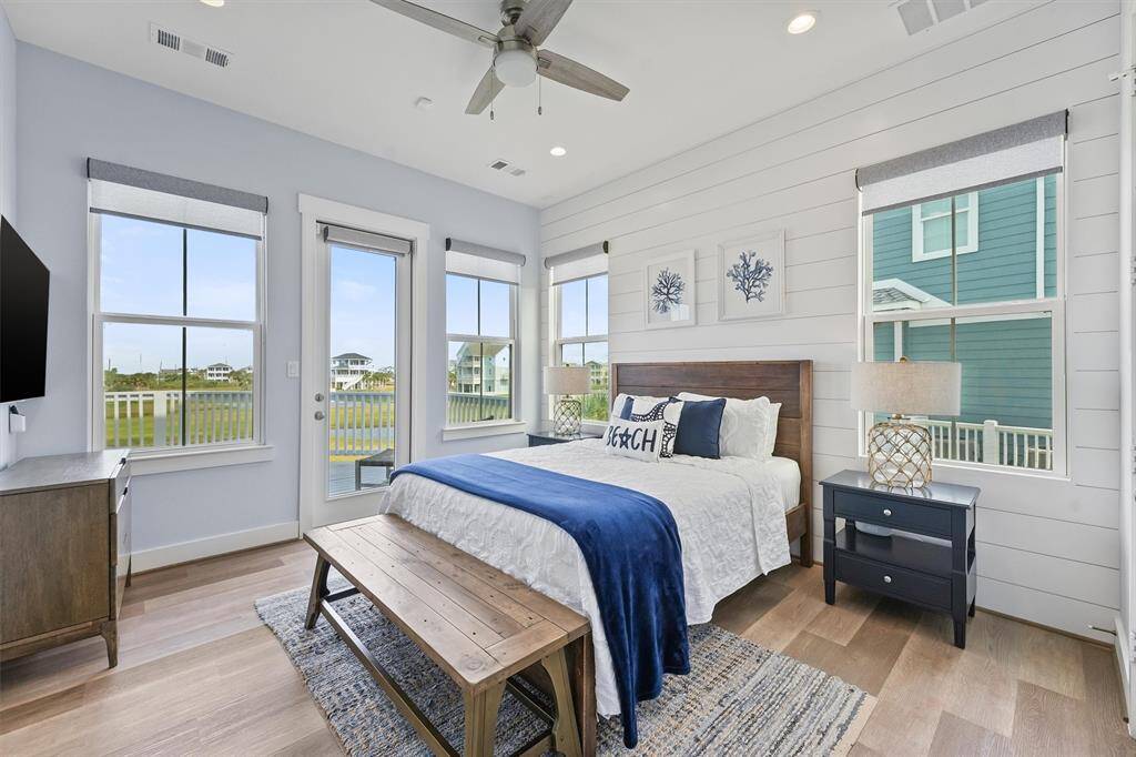This downstairs guest bedroomoffers a cozy and tranquil retreat,complete with shiplap walls andlarge windows that fill the roomwith natural light.