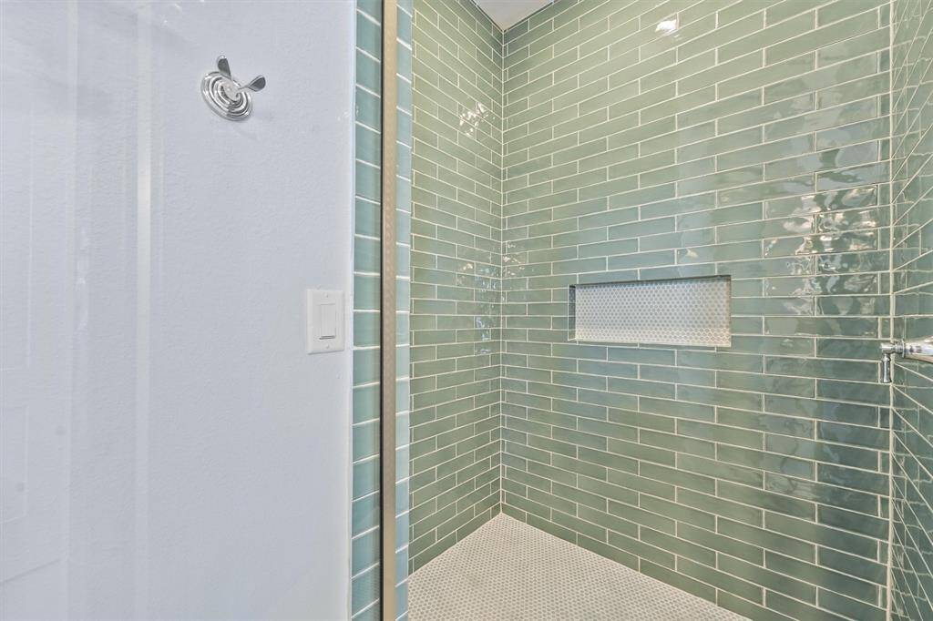 The en-suite bathroom isfinished with a fully tiled walk-inshower, featuring sleek greensubway tiles and a built-in nichefor added functionality.