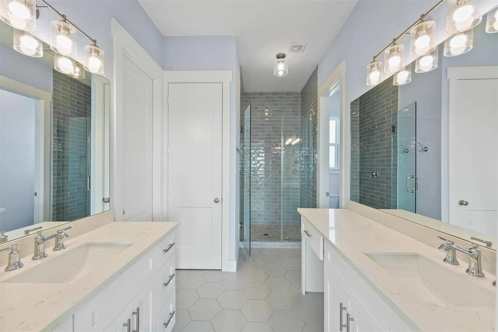 The luxurious ensuite bathfeatures dual vanities with sleekcountertops and modern lighting,offering plenty of space for yourmorning routine.