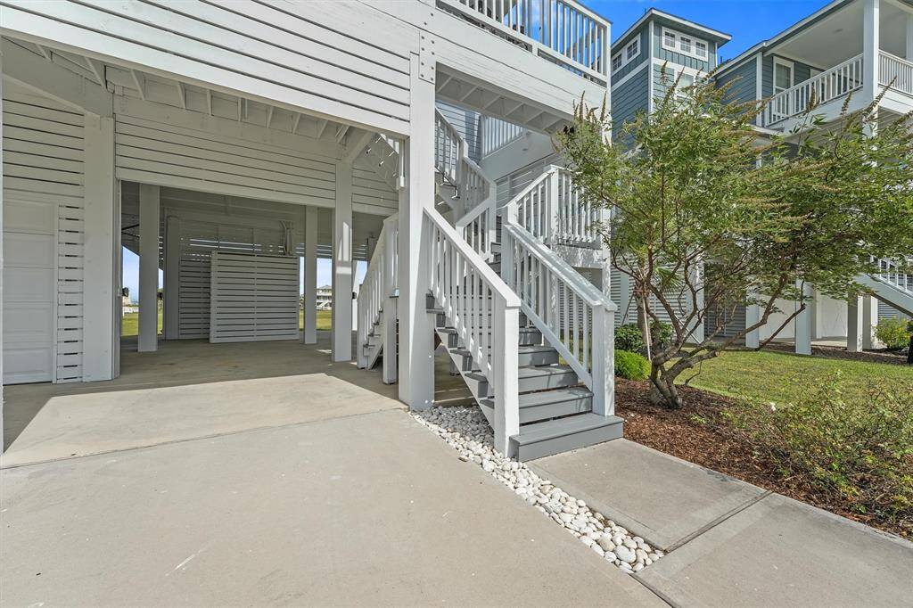 The stylish staircase and well-maintained landscapingwelcome you to this thoughtfullydesigned coastal retreat.