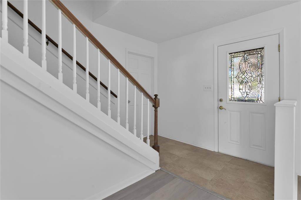 Front door entry...and staircase. Primary bedroom is to the right of the entry.