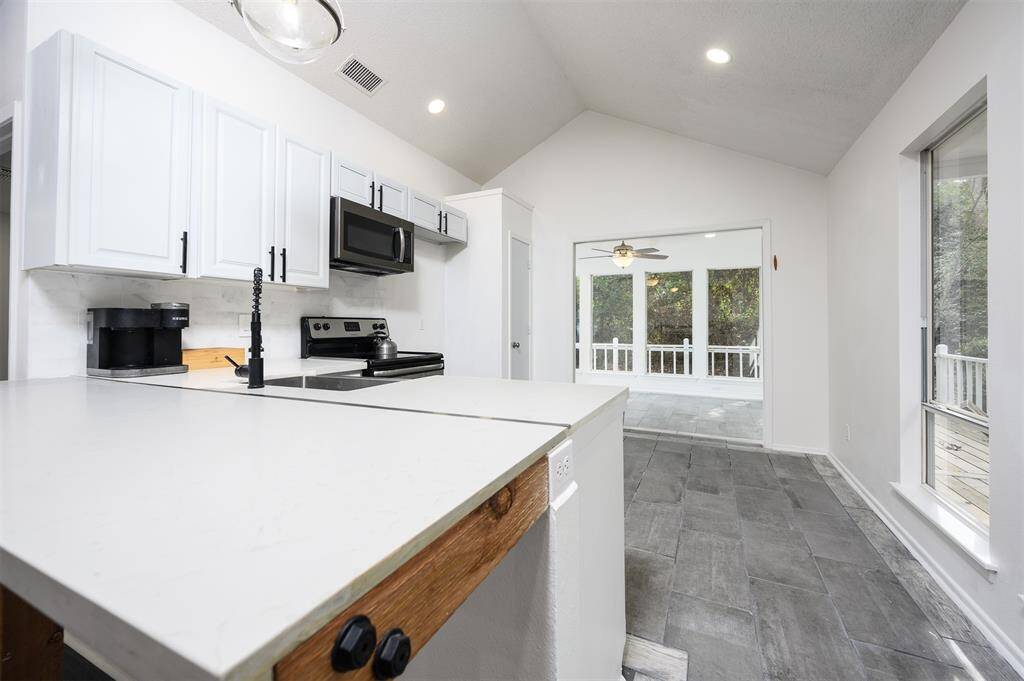 Oversized quartz breakfast bar looking into the kitchen and sun room