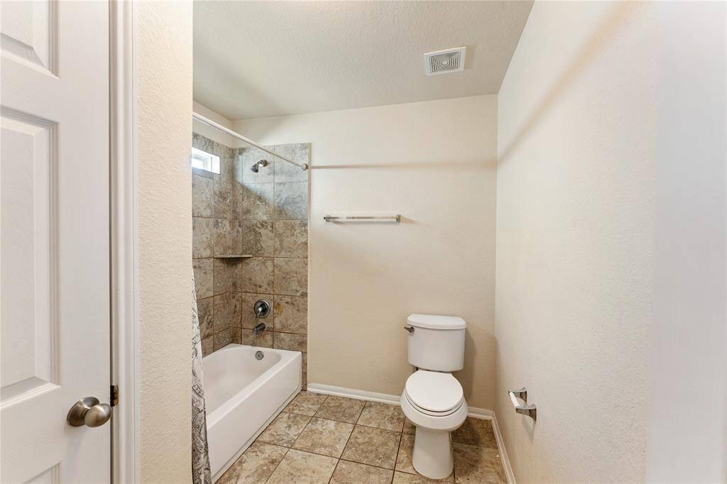 This is a secondary section of bathroom, modern bathroom with a tiled shower, a small window for natural light, a bathtub, a toilet, and tiled flooring.