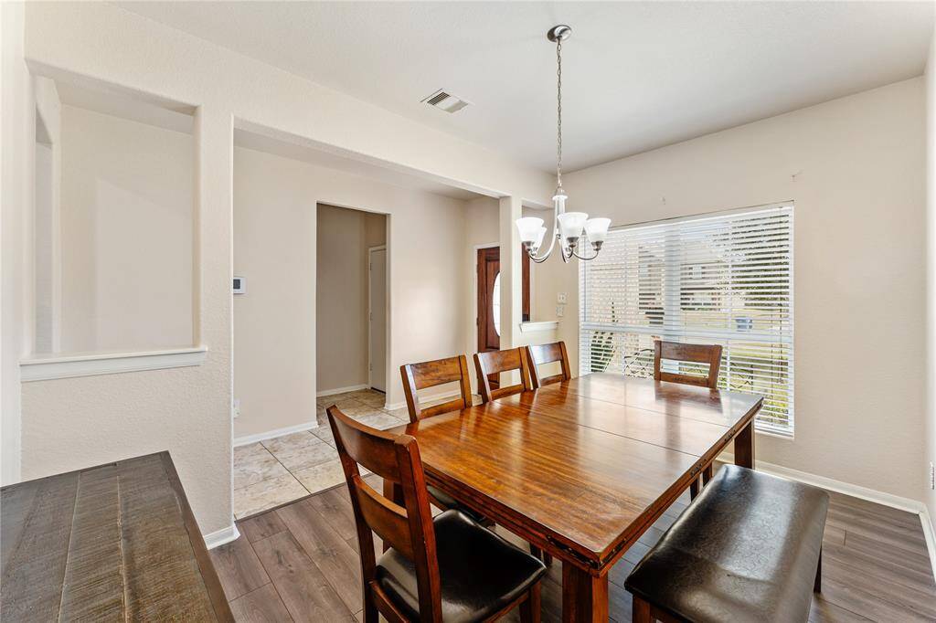 The Open Room Features A Neutral Color Palette With A Spacious Dining Area, And Ample Natural Light From Large Windows.