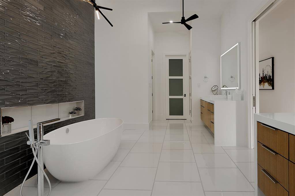 Freestanding soaking tub (Victoria & Albert), a tile feature wall & double vanity with wood accents. Kohler porcelain sinks & faucets in all bathrooms.Grohe plumbing fixtures in all showers.